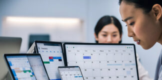 SME-employee-managing-employee-work-schedules-on-multiple-screens