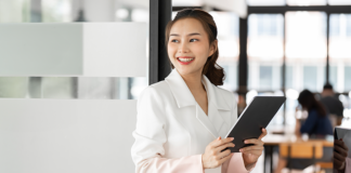 Smiling HR professional using tablet for efficient workforce management.
