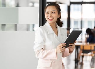 Smiling HR professional using tablet for efficient workforce management.