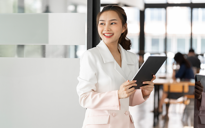 efficient-sme-workforce-management-hr-manager Smiling HR professional using tablet for efficient workforce management.