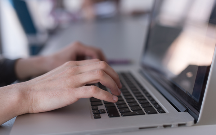 Hands typing accurate payroll data on a laptop keyboard. Hands typing accurate payroll data on a laptop keyboard.