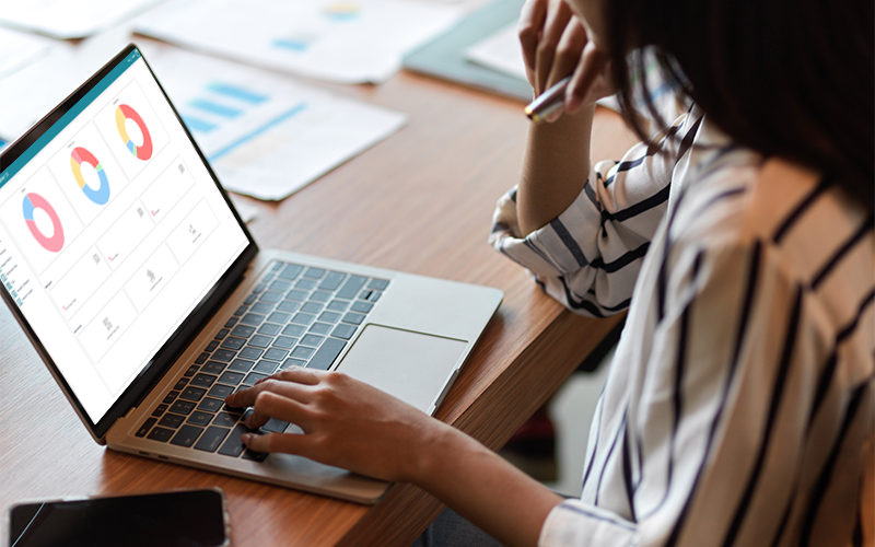 HR manager tracking workforce management analytics on laptop dashboard.