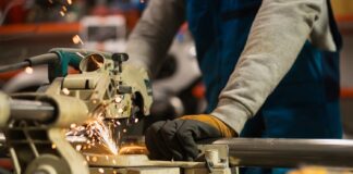 factory-worker-cutting-metal-pipe-in-manufacturing-labour-production