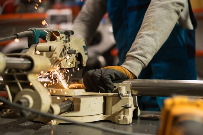 factory-worker-cutting-metal-pipe-in-manufacturing-labour-production factory-worker-cutting-metal-pipe-in-manufacturing-labour-production